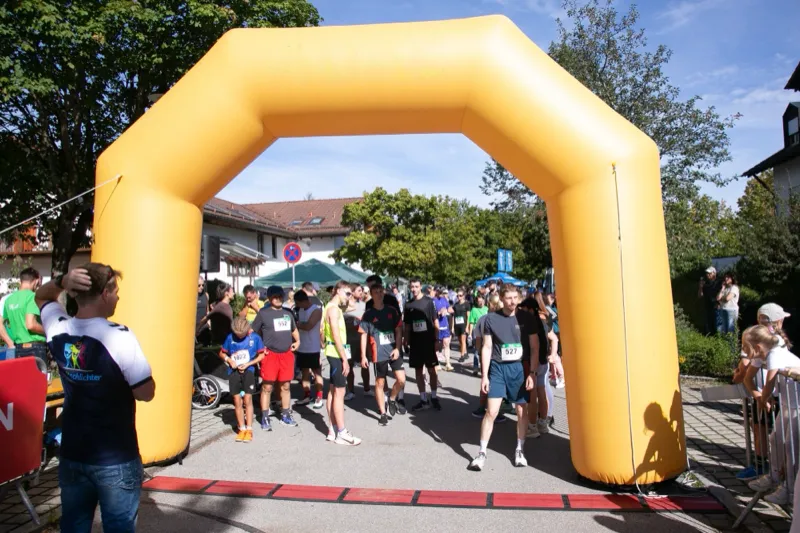 Läuferinnen und Läufer sammeln sich unter dem Startbogen vor dem Start.